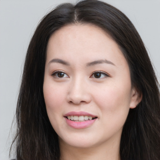 Joyful asian young-adult female with long  brown hair and brown eyes