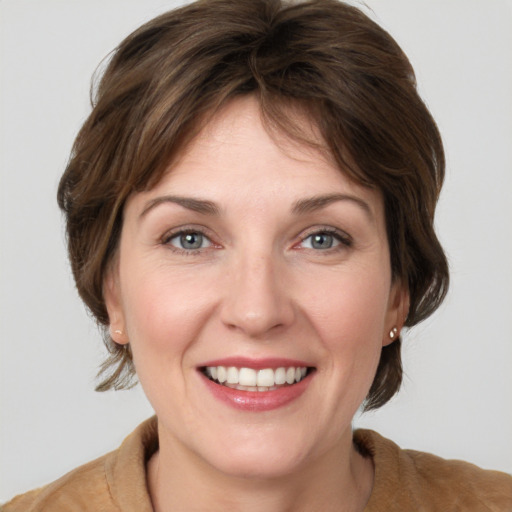 Joyful white young-adult female with medium  brown hair and grey eyes