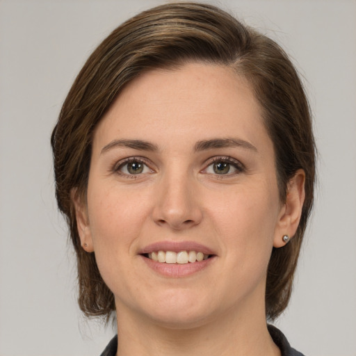 Joyful white young-adult female with medium  brown hair and grey eyes