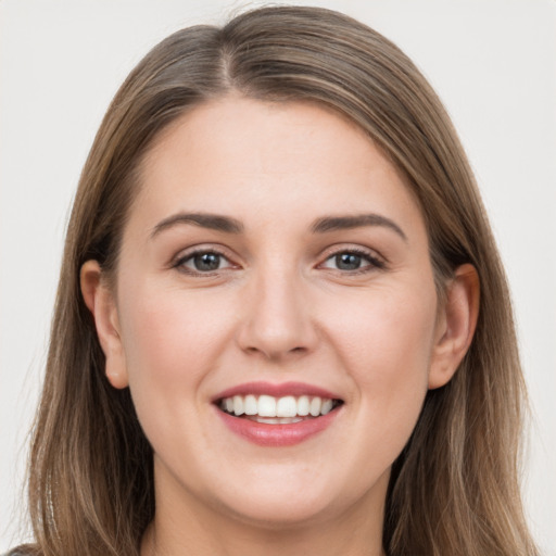 Joyful white young-adult female with long  brown hair and grey eyes