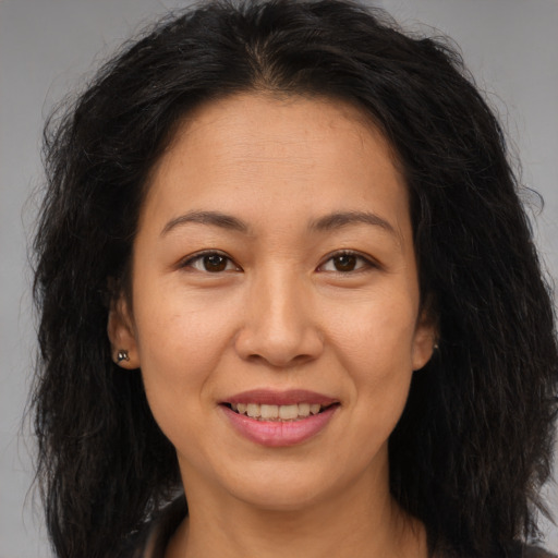Joyful asian adult female with long  brown hair and brown eyes