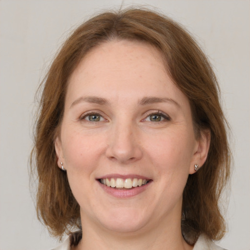 Joyful white young-adult female with medium  brown hair and grey eyes