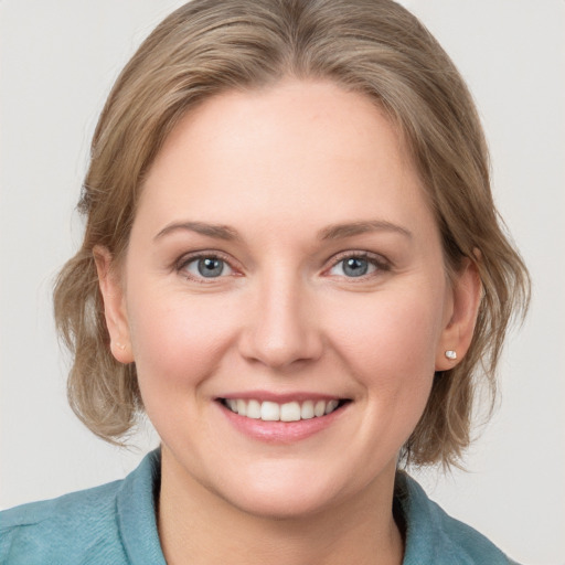 Joyful white young-adult female with medium  brown hair and blue eyes