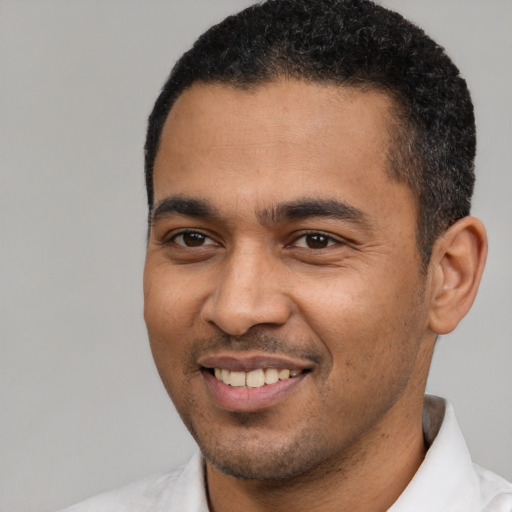 Joyful black young-adult male with short  black hair and brown eyes