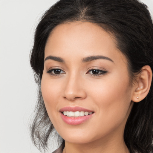 Joyful latino young-adult female with long  brown hair and brown eyes