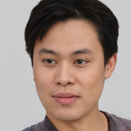 Joyful asian young-adult male with short  brown hair and brown eyes