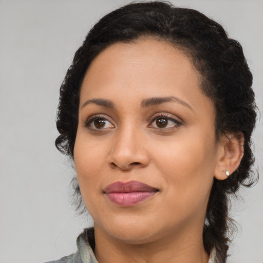 Joyful black young-adult female with long  brown hair and brown eyes