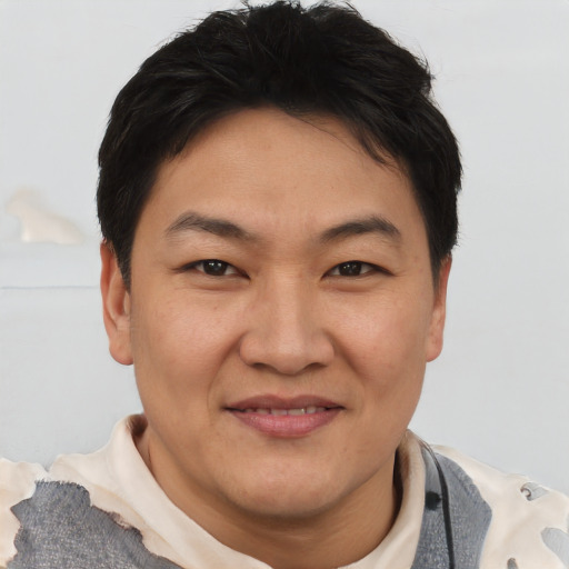 Joyful asian adult male with short  brown hair and brown eyes