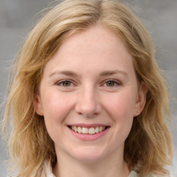 Joyful white young-adult female with medium  brown hair and blue eyes