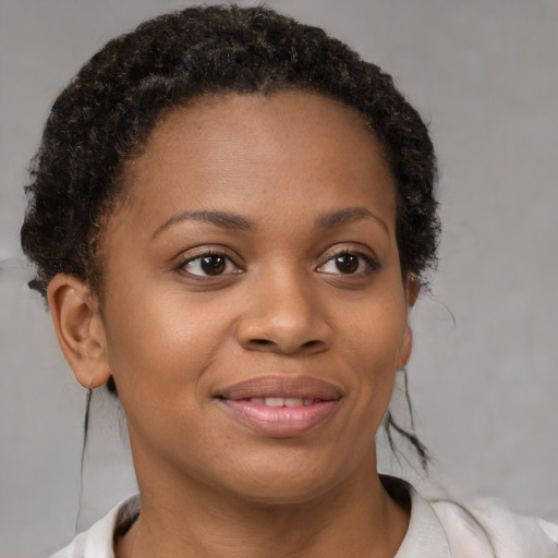 Joyful black young-adult female with short  brown hair and brown eyes