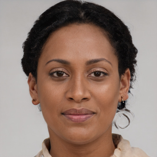 Joyful black adult female with short  brown hair and brown eyes