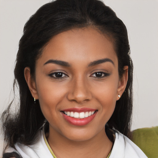 Joyful latino young-adult female with long  brown hair and brown eyes