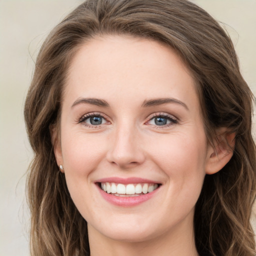 Joyful white young-adult female with long  brown hair and green eyes