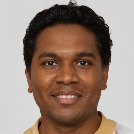 Joyful black young-adult male with short  black hair and brown eyes