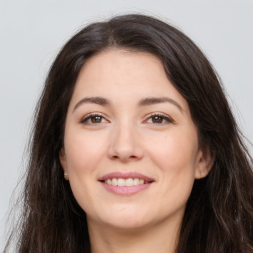 Joyful white young-adult female with long  brown hair and brown eyes