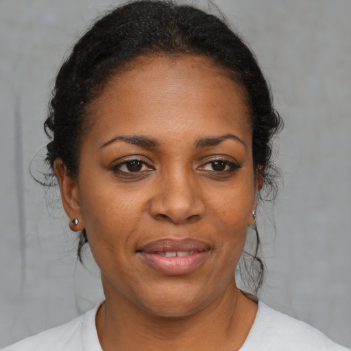 Joyful black adult female with medium  brown hair and brown eyes