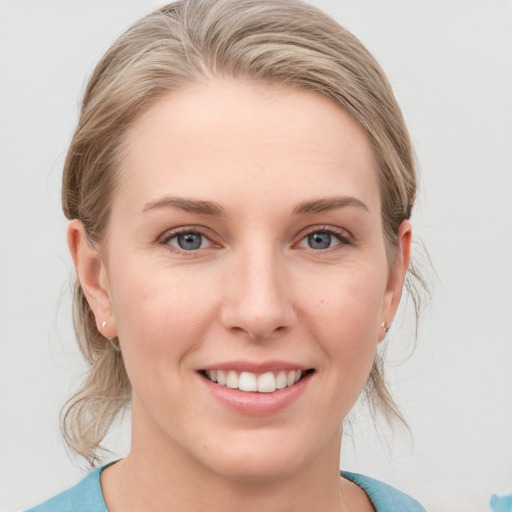 Joyful white young-adult female with medium  brown hair and blue eyes