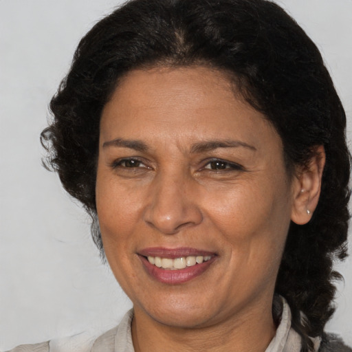 Joyful black adult female with medium  brown hair and brown eyes