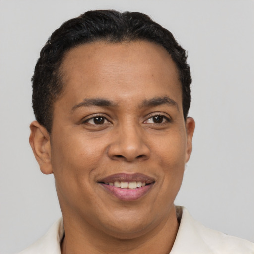 Joyful latino young-adult male with short  brown hair and brown eyes