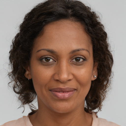 Joyful black adult female with medium  brown hair and brown eyes