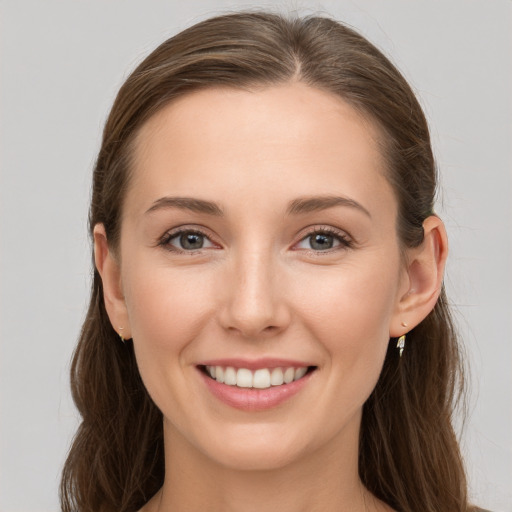 Joyful white young-adult female with long  brown hair and grey eyes