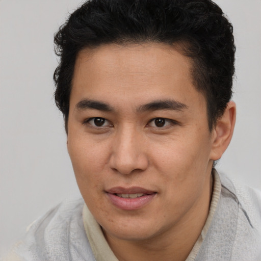 Joyful latino young-adult male with short  brown hair and brown eyes