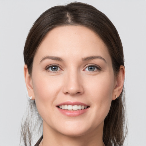 Joyful white young-adult female with medium  brown hair and grey eyes