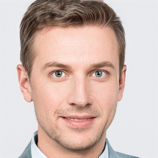 Joyful white young-adult male with short  brown hair and blue eyes