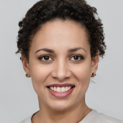 Joyful black young-adult female with short  brown hair and brown eyes