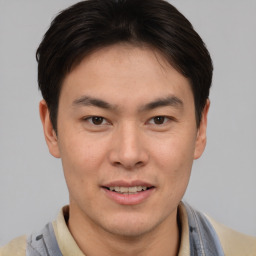 Joyful asian young-adult male with short  brown hair and brown eyes