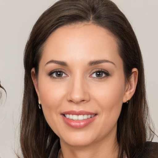 Joyful white young-adult female with long  brown hair and brown eyes