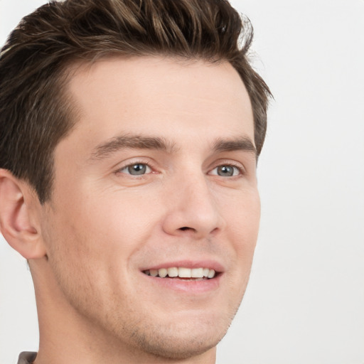 Joyful white young-adult male with short  brown hair and grey eyes