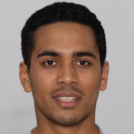 Joyful black young-adult male with short  black hair and brown eyes