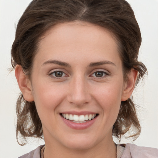 Joyful white young-adult female with medium  brown hair and grey eyes