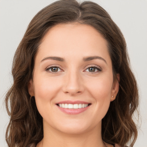 Joyful white young-adult female with long  brown hair and green eyes