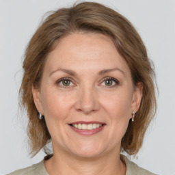 Joyful white adult female with medium  brown hair and grey eyes