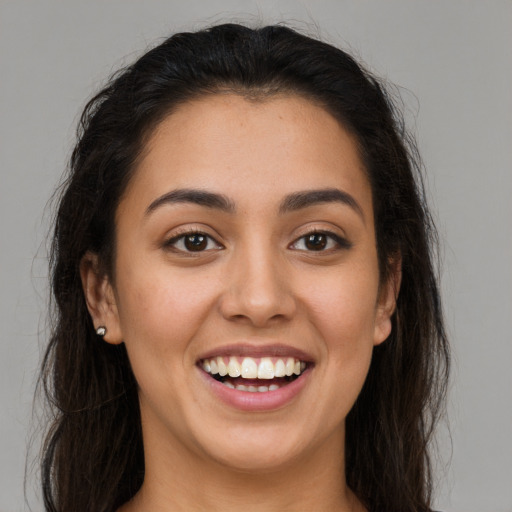 Joyful latino young-adult female with long  brown hair and brown eyes