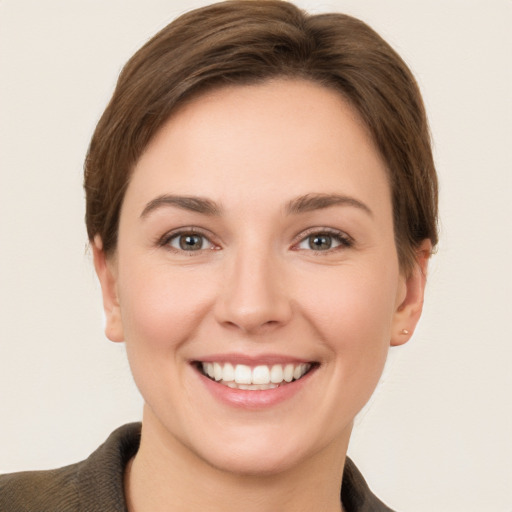 Joyful white young-adult female with short  brown hair and grey eyes