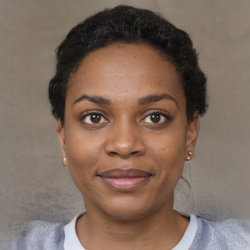 Joyful black young-adult female with short  black hair and brown eyes