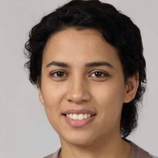 Joyful latino young-adult female with short  black hair and brown eyes