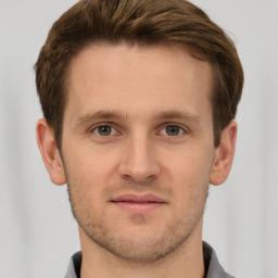 Joyful white young-adult male with short  brown hair and grey eyes