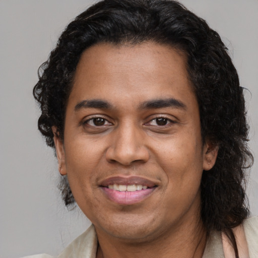Joyful black young-adult male with medium  black hair and brown eyes