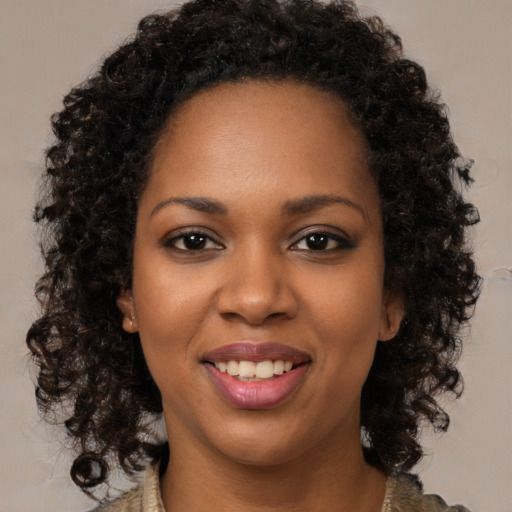Joyful black young-adult female with long  brown hair and brown eyes
