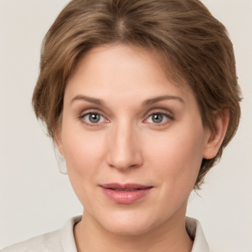 Joyful white young-adult female with medium  brown hair and grey eyes