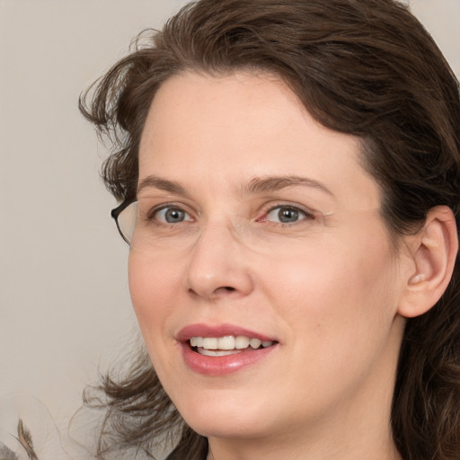 Joyful white adult female with medium  brown hair and brown eyes