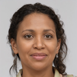 Joyful black adult female with medium  brown hair and brown eyes