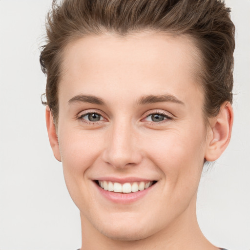 Joyful white young-adult female with short  brown hair and grey eyes