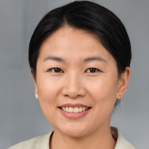 Joyful asian young-adult female with short  brown hair and brown eyes