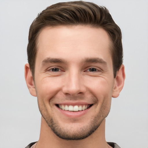 Joyful white young-adult male with short  brown hair and grey eyes