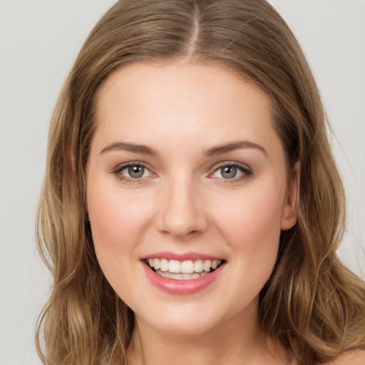 Joyful white young-adult female with long  brown hair and green eyes